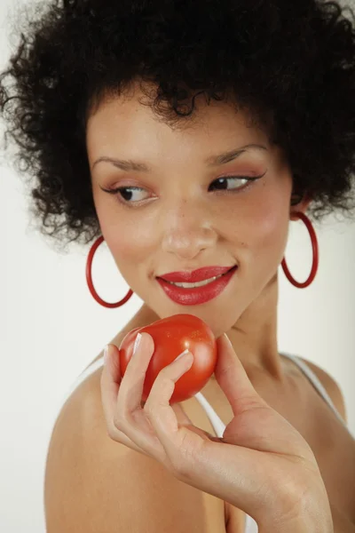 African girl with a tomato in hand — Stock Photo, Image