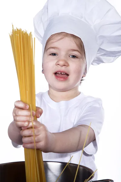 Little girl cooking noodles in a large pot — Stock Photo, Image