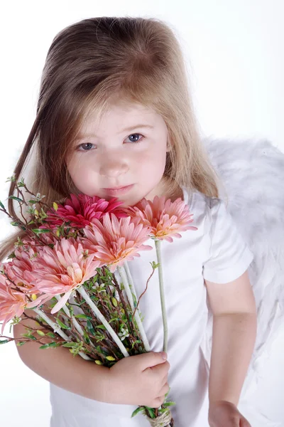 Kleines Mädchen mit Engelsflügeln hält einen Blumenstrauß — Stockfoto