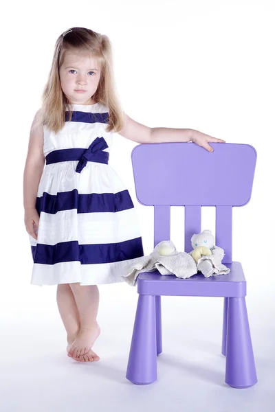 Little girl with toy on Plastic chair — Stock Photo, Image