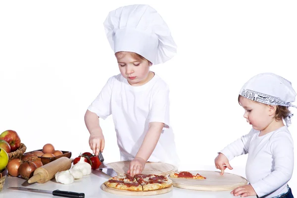 Две маленькие девочки готовят пиццу. — стоковое фото