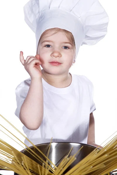 Kleines Mädchen kocht Nudeln in einem großen Topf — Stockfoto