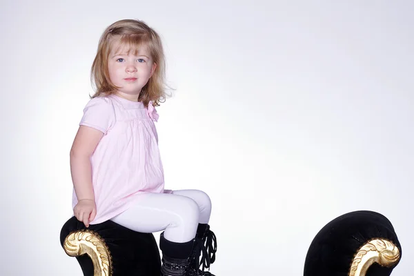 Eski bir koltuğa oturan küçük kız — Stok fotoğraf