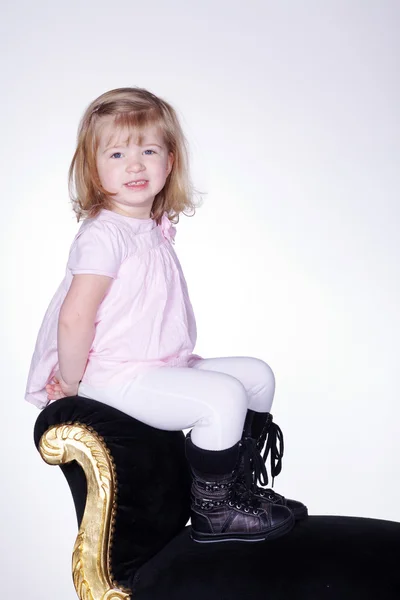 Niña sentada en un viejo sillón — Foto de Stock