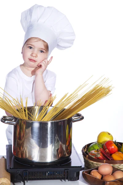 Kleines Mädchen kocht Nudeln in einem großen Topf — Stockfoto