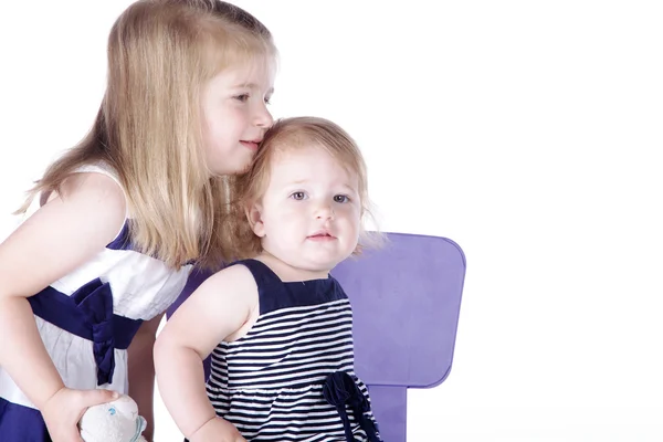 Twee meisjes zitten op een stoel — Stockfoto