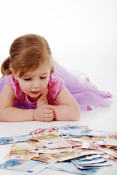 En liten flicka med pappers-pengar — Stockfoto
