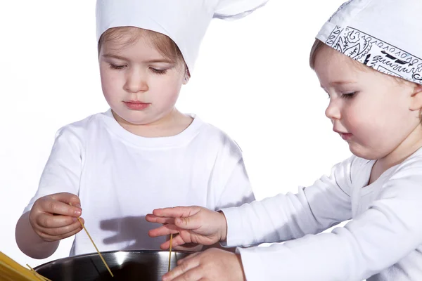 Two little girls are preparing spaghetti — Stock Photo, Image