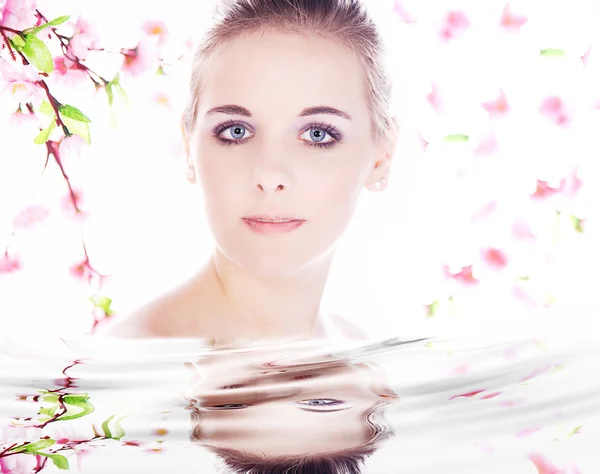 La cara de la niña reflejada en el agua con la flora — Foto de Stock