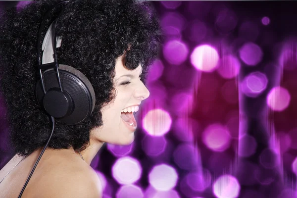 Curly brunette girl in headphones — Stock Photo, Image