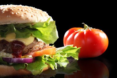 hamburger ve ahşap bir masa üzerinde domates