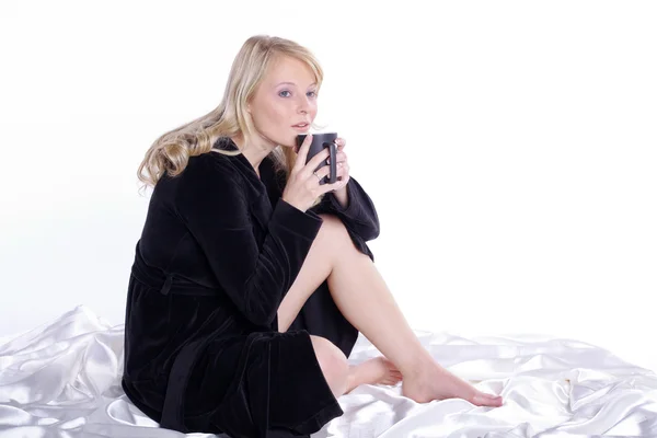 Blondes Mädchen sitzt mit einer Tasse Tee auf dem Boden — Stockfoto