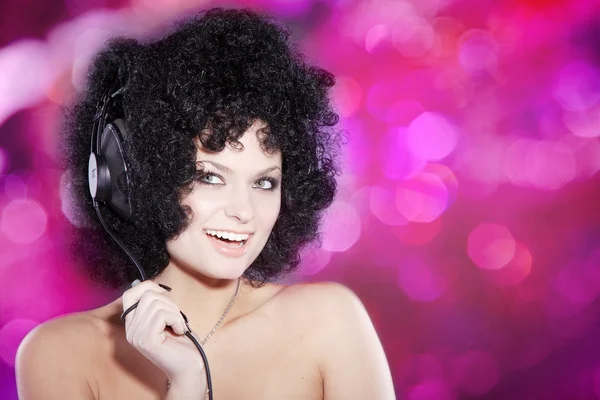 Curly brunette girl in headphones — Stock Photo, Image
