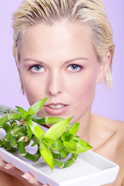 Blonde girl with green branches — Stock Photo, Image