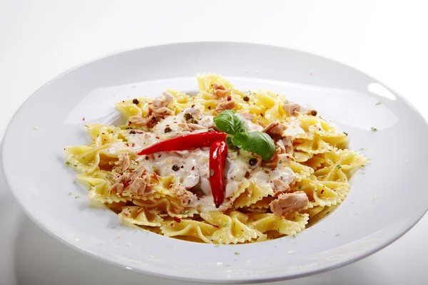 Fresh pasta with basil leaf and red hot pepper on white dish — Stock Photo, Image