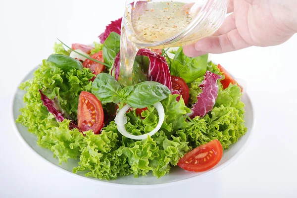 Человек добавляет приправы в салат с овощами — стоковое фото