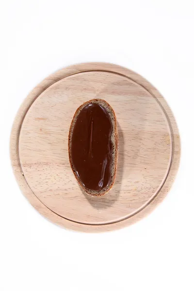 Bread with chocolate spread on a wooden board — Stock Photo, Image