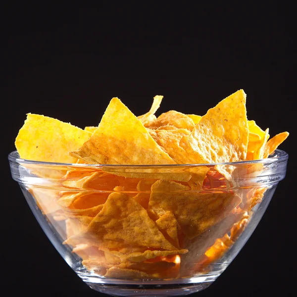 Szkła miskę ze kupie chipsów — Zdjęcie stockowe