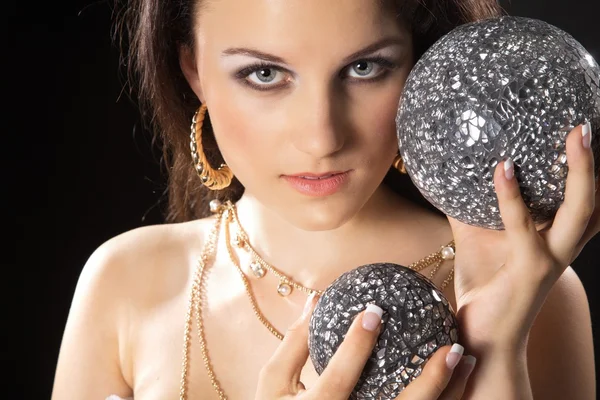 Morena chica con bolas de plata en las manos —  Fotos de Stock