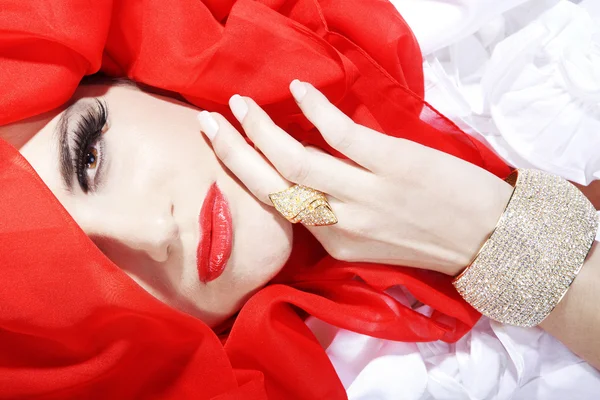 Brunette girl in red and white curtain — Stock Photo, Image