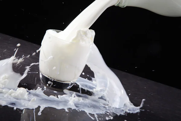 Milk is poured into a glass — Stock Photo, Image