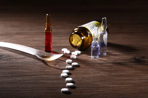 Pilulky na dřevěném stole — Stock fotografie