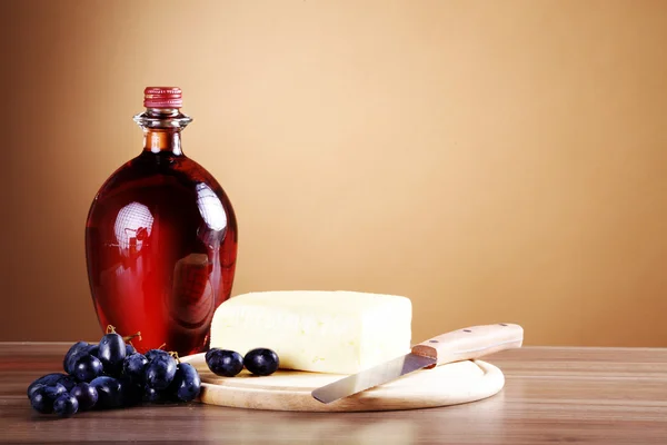 Grapes, oil and cheese on a wooden table — Stock Photo, Image