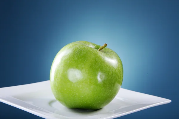 Μήλο σε λευκό πιάτο — Φωτογραφία Αρχείου