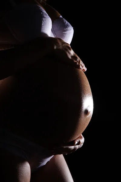 Fille enceinte sur un fond sombre — Photo