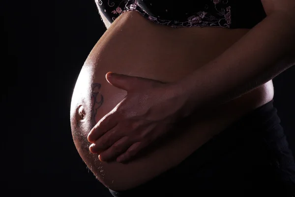 Menina grávida em um fundo escuro — Fotografia de Stock