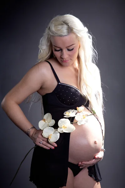 Schwangere Mädchen mit Orchideen — Stockfoto