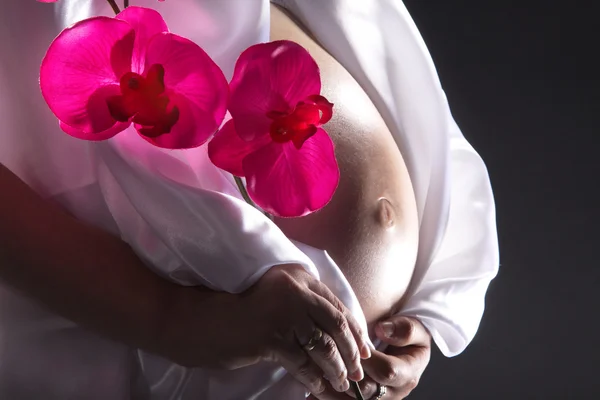 Menina grávida com orquídeas — Fotografia de Stock