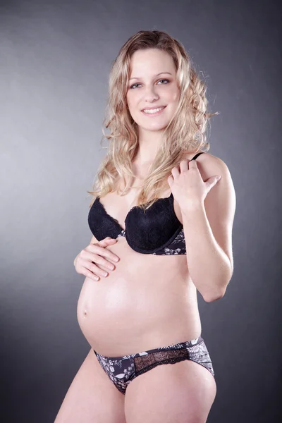 Těhotná blondýnka ve spodním prádle — Stock fotografie