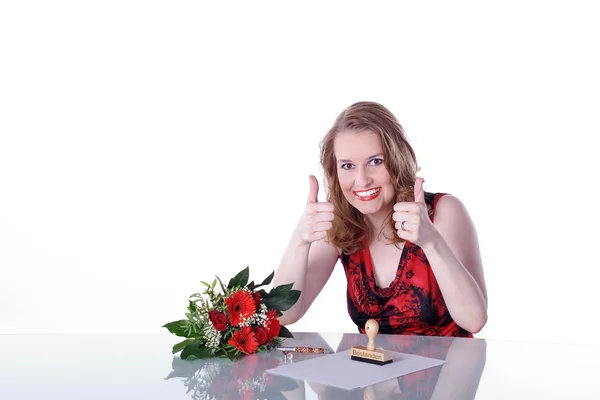 Meisje zit aan een tafel met bloemen — Stockfoto