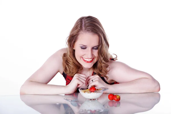 Meisje zit aan een tafel met aardbeien — Stockfoto