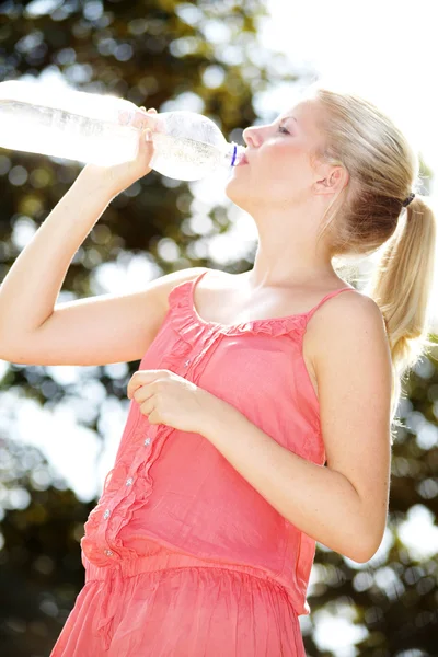 Blonďatá holka pije vodu v lahvi — Stock fotografie