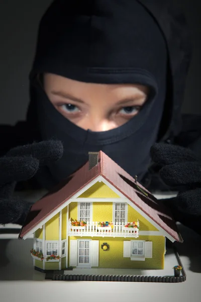Menina ladrão com modelo de casa — Fotografia de Stock