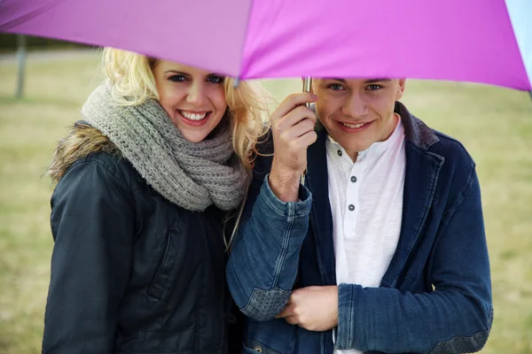 Młoda para pod parasolem — Zdjęcie stockowe