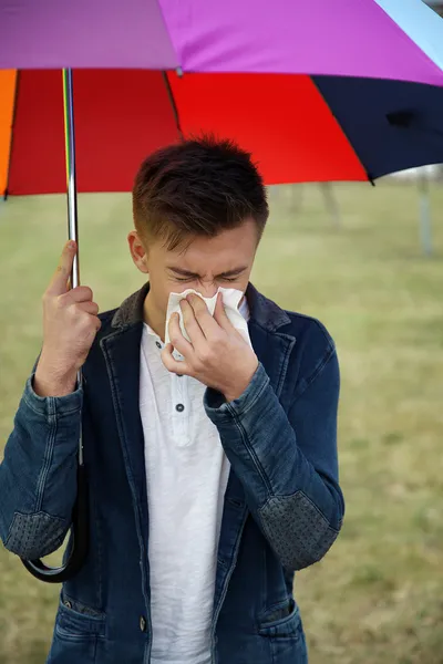 Junge mit Regenschirm schneidet sich in Taschentuch — Stockfoto