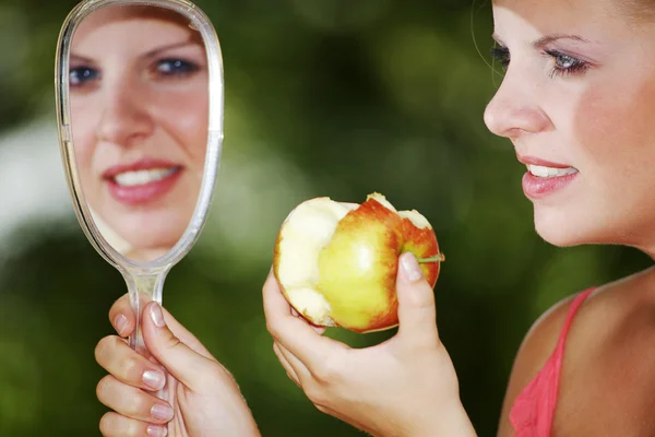 Blonde girl with apple and mirror — Stock Photo, Image