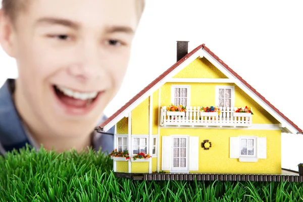 Boy with a model home on the grass — Stock Photo, Image