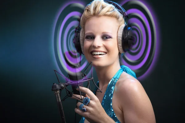 Blondes Mädchen singt in ein Mikrofon — Stockfoto