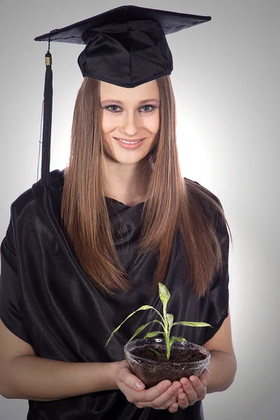 Graduate student with a plant in a glass pot — Stock Photo, Image