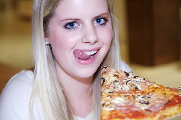 Blond flicka äter pizza Royaltyfria Stockbilder