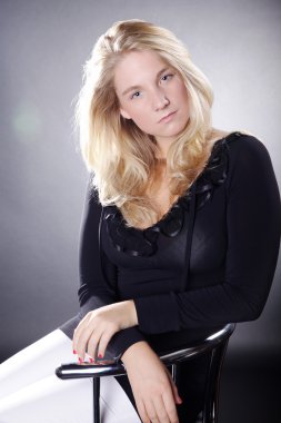 bir sandalyede oturan sarışın kız