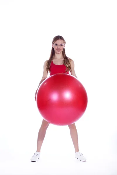 Mujer deportiva haciendo ejercicio con una pelota suiza — Foto de Stock