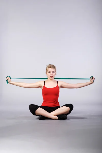 Женщина делает упражнения с полосой сопротивления — стоковое фото