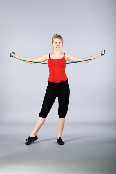 Woman doing exercises with a resistance band — Stock Photo, Image