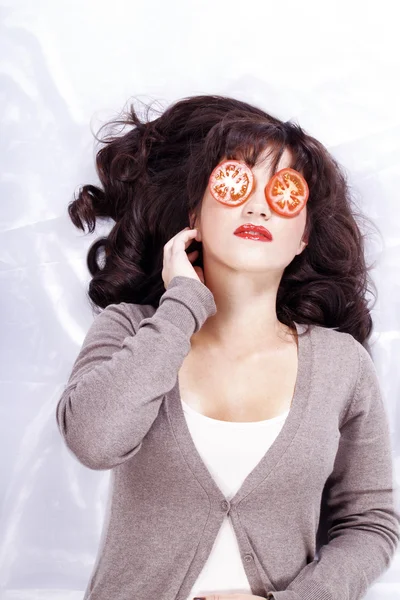 Brunette girl with tomatoes on the eyes — Stock Photo, Image
