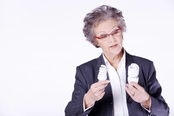 Seniorin mit Energiesparlampe — Stockfoto